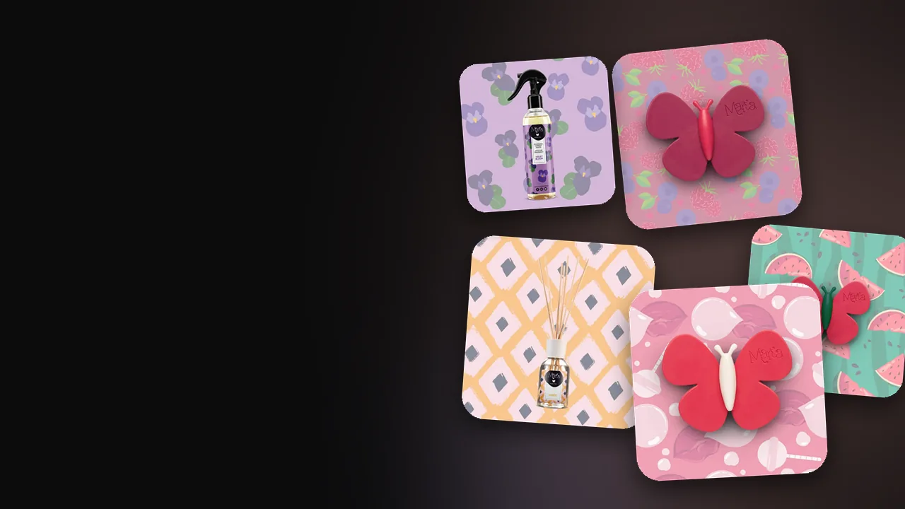 Perfumes en forma de mariposa de Marta la Farfalla, difusor de varillas y spray sobre un fondo oscuro
